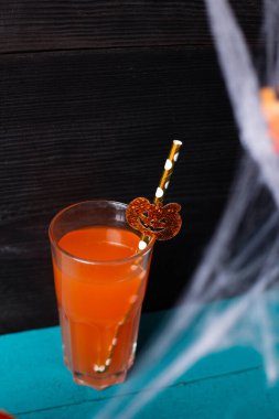 Cadılar Bayramı için bir bardak meyve suyu, balkabağı ve örümcek ağı.