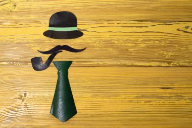 Sarı arka planda kağıttan yapılmış bir beyefendinin görüntüsü.