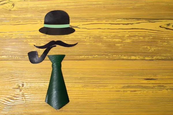 Sarı arka planda kağıttan yapılmış bir beyefendinin görüntüsü.