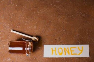 Güzel bir arka planda tahta kaşıkla bir kavanoz bal.