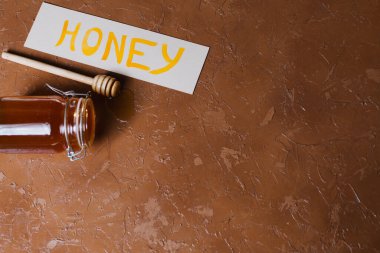 Güzel bir arka planda tahta kaşıkla bir kavanoz bal.