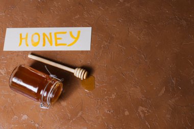 Güzel bir arka planda tahta kaşıkla bir kavanoz bal.