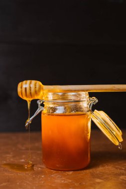 Koyu arkaplanda bir kavanoz bal