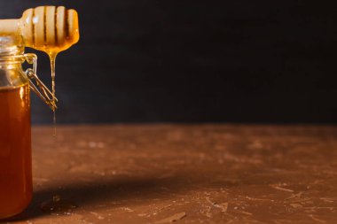 Koyu arkaplanda bir kavanoz bal