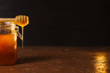 Koyu arkaplanda bir kavanoz bal