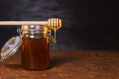 Koyu arkaplanda bir kavanoz bal