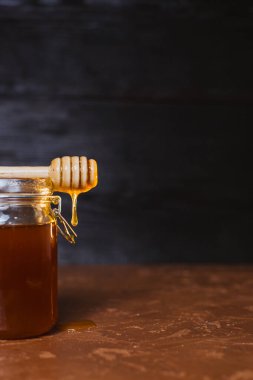 Koyu arkaplanda bir kavanoz bal