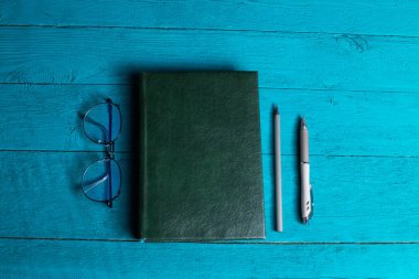 Gözlüklü ve kalemli bir defter..