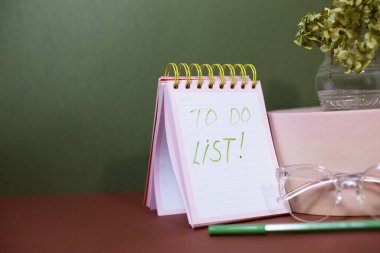 Masada gözlük, kalem ve filizli defter var..