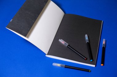 Mavi arka planda keçeli kalemli defter.