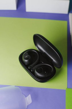 Çantalı siyah kablosuz kulaklıklar ve güzel bir arka planı olan beyaz bir kutu.