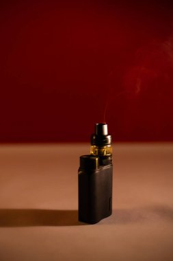 Güzel, koyu bir arka planda, dumanlı elektronik sigara.