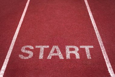 Spor müsabakaları ve sprint yarışları için bir stadyumda beyaz şeritli kırmızı koşu pisti