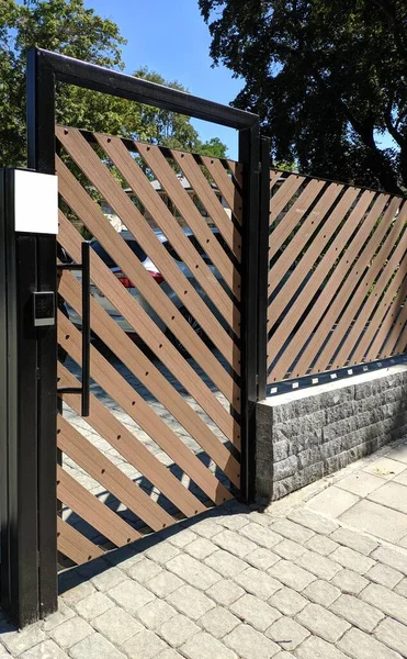 Metal automatic gates of the entrance area. Plastic doors with lifting mechanism. Stock