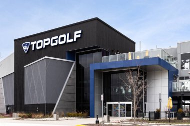 Schaumburg, IL, USA - March 27, 2024: TopGolf features multiple floors of driving range bays and is a fun entertainment complex for all ages to enjoy. clipart