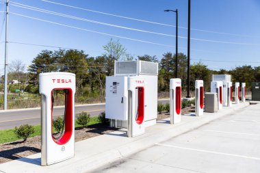 Sevierville, TN, ABD - 13 Nisan 2024: Aracı olmayan bir otoparktaki beyaz ve kırmızı Tesla şarj istasyonları.