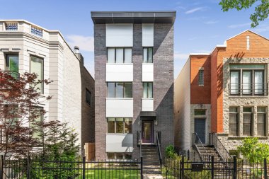 Oak Park, IL, ABD - 5 Temmuz 2020: Lüks, modern üç katlı, arka planda mavi gökyüzü olan bir tuğla ev.