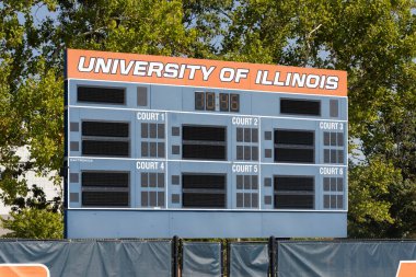 Champaign, IL, USA - September 18, 2024: Tennis Courts at the University of Illinois. The courts are themed with orange and blue with Fighting Illini signs around the fence. clipart