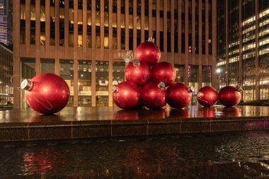 New York, New York, ABD - 11 Aralık 2023: Times Meydanı 'ndaki Dev Kırmızı Noel Süslemeleri 1251. Cadde' de ve tatil için ikonik turizm merkezlerinden birinde yer almaktadır..
