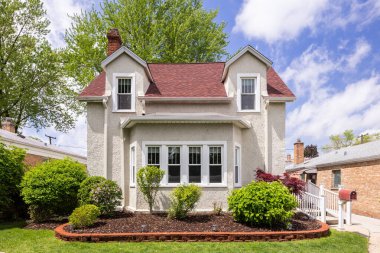 River Forest, IL, ABD - 7 Mayıs 2024: Beyaz çerçeveli, kırmızı kiremitli ve güzel manzaralı tek bir aile sıva evi.