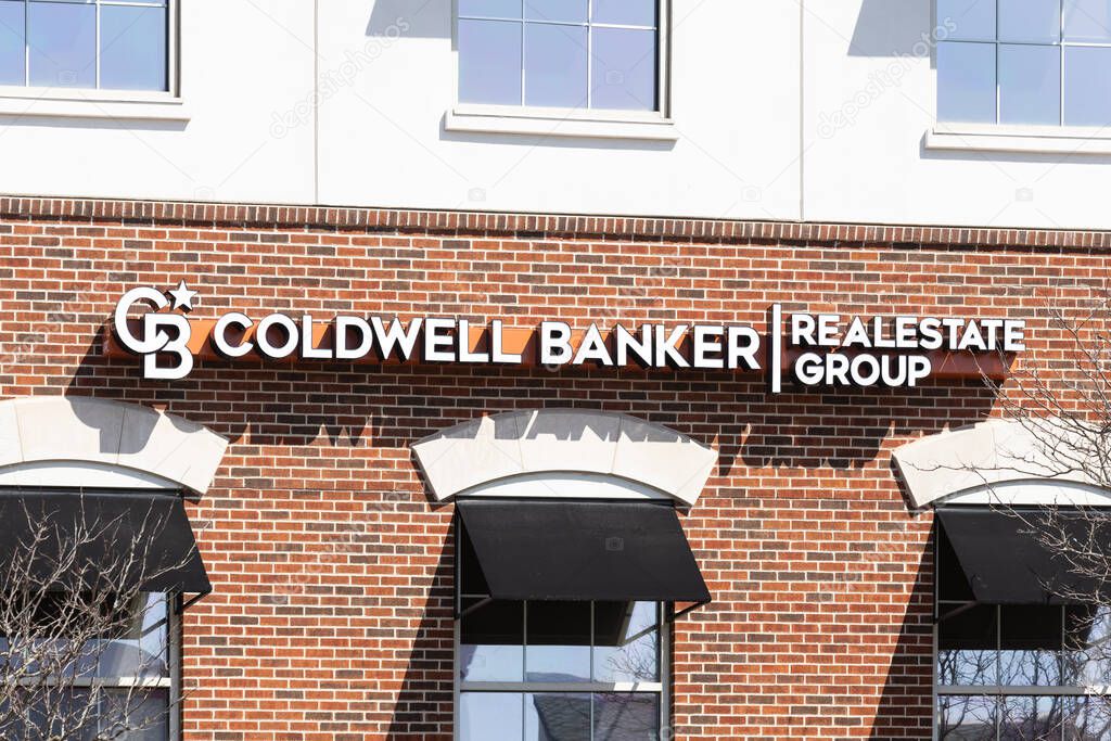 Naperville, IL, USA - April 8, 2025: The Coldwell Banker Real Estate Group logo on a brick office building in downtown Naperville, IL.