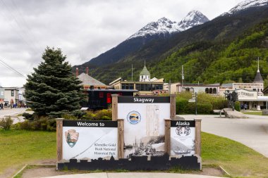 Skagway, AK, ABD - 2 Haziran 2025: Konuklar şehre girerken Skagway tabelasına hoş geldiniz. Burası Alaska seyahati yapan konuklar için popüler bir gemi limanı..