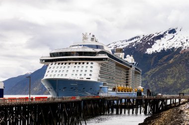 Skagway, AK, ABD - 2 Haziran 2025: Kraliyet Karayipleri 'nin Deniz Yolcu Gemisi Marşı, şirket filosunun Kuantum Sınıfı' nda yer almaktadır. Alaska 'nın dağları arka planda görülebilir..