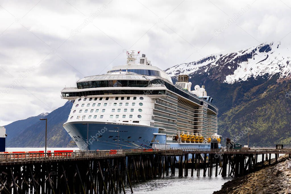 Skagway, AK, USA - June 2, 2025: Royal Caribbean's Anthem of the Seas cruise ship is in the Quantum Class of the companies fleet. Alaska's mountains can be seen in the background.