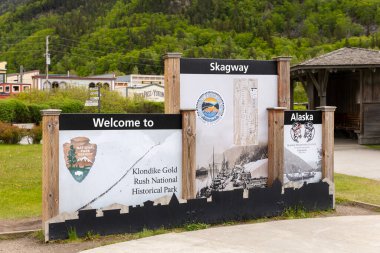 Skagway, AK, ABD - 2 Haziran 2025: Konuklar şehre girerken Skagway tabelasına hoş geldiniz. Burası Alaska seyahati yapan konuklar için popüler bir gemi limanı..