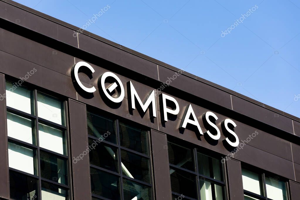 Seattle, WA, USA - May 30, 2025: The Compass Real Estate logo on a brick office building in downtown Seattle, WA.