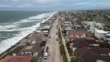4K hava manzaralı İHA Güney Kaliforniya 'da bir sahil şeridinde çekildi. Mavi Pasifik Okyanusu' nda dalgalar geliyor ve arka planda güzel evler var. Güçlü rüzgar büyük dalgalar yaratıyor.