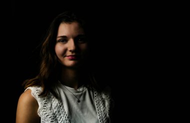 Siyah arka planda genç bir kadının portresi