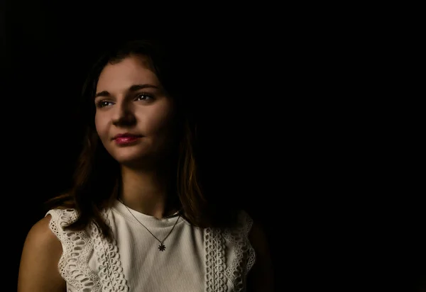 Portrait of a young woman on black background