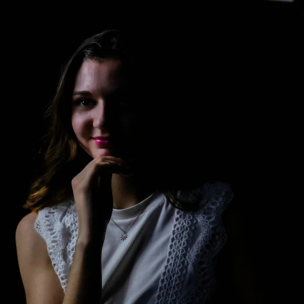 Portrait of a young woman on black background