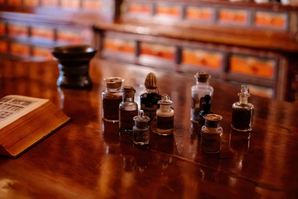 stock image Kuks, Czech Republic, 8 October 2022: interior of historic pomegranate apple pharmacy, vintage glass bottles on wooden table, shelf, medical background, museum antique drugstore, jars with cork lids