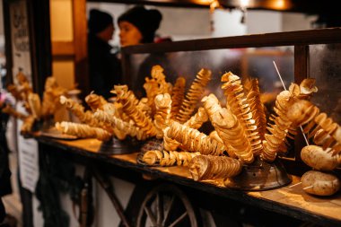 Dresden, Saksonya, Almanya, 10 Aralık 2022: Noel ortaçağ açık hava market dekorasyonları ışıklarla perili, Stallhof sarayın yanında, tahta çubukta kızarmış patates, yiyecek satışı