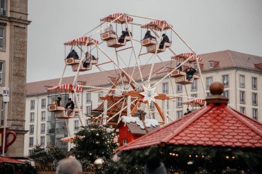 Dresden, Saksonya, Almanya, 10 Aralık 2022: Işıklı Noel tezgahı süslemeleri, ahşap dönme dolap, yolcular için kamaralar, turistler için eğlence, kış günü ve kar.