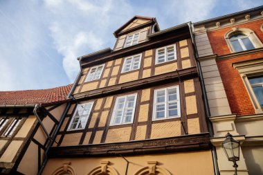 Quedlinburg, Saxony-Anhalt, Germany, 28 October 2022: Historic old vintage colored timber frame houses in medieval town, UNESCO World Heritage city, half-timbered home at sunny autumn day, cobblestone