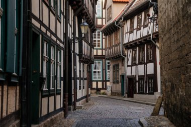 Quedlinburg, Saxony-Anhalt, Germany, 28 October 2022: Historic old vintage colored timber frame houses in medieval town, UNESCO World Heritage city, half-timbered home at sunny autumn day, cobblestone