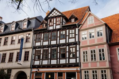 Quedlinburg, Saxony-Anhalt, Germany, 28 October 2022: Historic old vintage colored timber frame houses in medieval town, UNESCO World Heritage city, half-timbered home at sunny autumn day, cobblestone