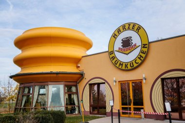 Wernigerode, Saxony-Anhalt, Germany, 29 October 2022:  Harzer-Baumkuchen Baumkuchenhaus or Harz Baumcake house, yellow cafe specializing in Baum cake, traditional dessert of city, sunny autumn day