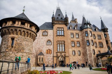 Wernigerode, Saxony-Anhalt, Germany, 29 October 2022:  Castle with tower in Harz mountains above town, Neo-Romantic style or historicism, Sculptures of griffins, dragon and eagles, sunny autumn day