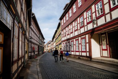Wernigerode, Saxony-Anhalt, Germany, 29 October 2022: Historic old vintage colored timber frame houses in medieval town, UNESCO World Heritage city, half-timbered home at sunny autumn day, cobblestone