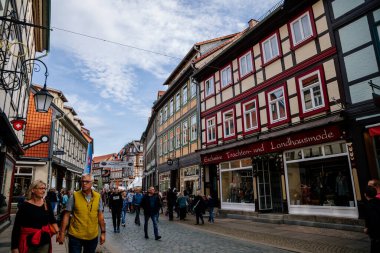 Wernigerode, Saxony-Anhalt, Germany, 29 October 2022: Historic old vintage colored timber frame houses in medieval town, UNESCO World Heritage city, half-timbered home at sunny autumn day, cobblestone