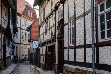 Wernigerode, Saxony-Anhalt, Germany, 29 October 2022: Historic old vintage colored timber frame houses in medieval town, UNESCO World Heritage city, half-timbered home at sunny autumn day, cobblestone