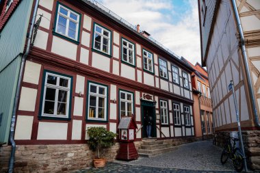 Wernigerode, Saxony-Anhalt, Germany, 29 October 2022: Historic old vintage colored timber frame houses in medieval town, UNESCO World Heritage city, half-timbered home at sunny autumn day, cobblestone