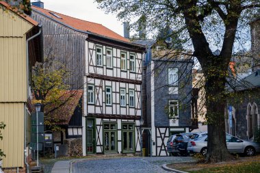 Wernigerode, Saxony-Anhalt, Germany, 29 October 2022: Historic old vintage colored timber frame houses in medieval town, UNESCO World Heritage city, half-timbered home at sunny autumn day, cobblestone