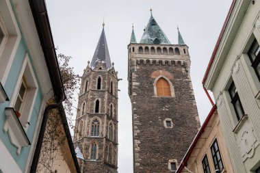 Kolin, Çek Cumhuriyeti, 17 Aralık 2022: Ortaçağ St. Bartholomew Kilisesi kış günü kar altında kulesi, kemerli pencereler, şempanzeler ve heykeller, çan kulesi olan Gotik Katedrali, Noel