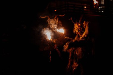 Trutnov, Çek Cumhuriyeti, 17 Aralık 2022: Geleneksel şov Zazij Krampus, maskeli şeytani yaratıklar geçidi, kış gecelerinde şeytan alevler içinde, Noel tatilleri, el yapımı ahşap maskeler