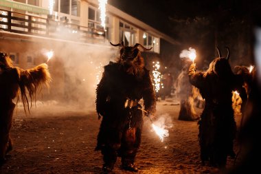 Trutnov, Çek Cumhuriyeti, 17 Aralık 2022: Geleneksel şov Zazij Krampus, maskeli şeytani yaratıklar geçidi, kış gecelerinde şeytan alevler içinde, Noel tatilleri, el yapımı ahşap maskeler